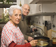 Elderly man and woman cooking together